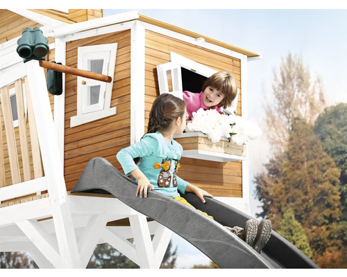 Cabane de jeu avec toboggan et enfants dans le jardin