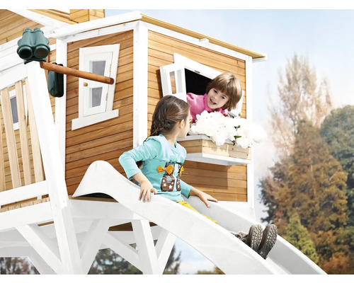 Des enfants jouent dans une cabane en bois avec toboggan et fenêtre