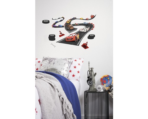 Sticker mural décoratif avec un motif de circuit Disney Cars au-dessus d''un lit d''enfant