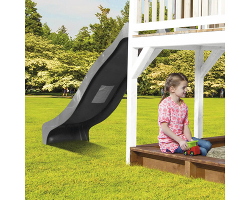 Tour de jeu avec toboggan et bac à sable dans le jardin avec enfant jouant