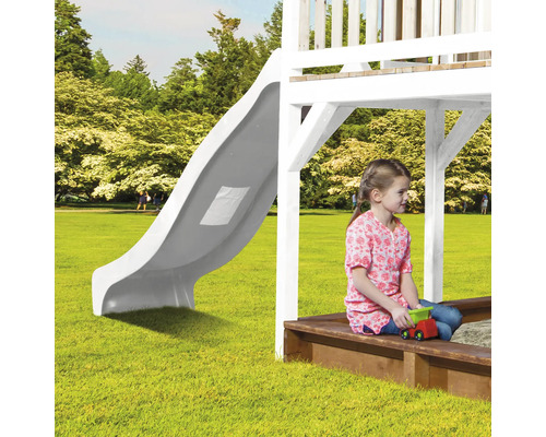 Enfant sur une aire de jeux avec toboggan et bac à sable