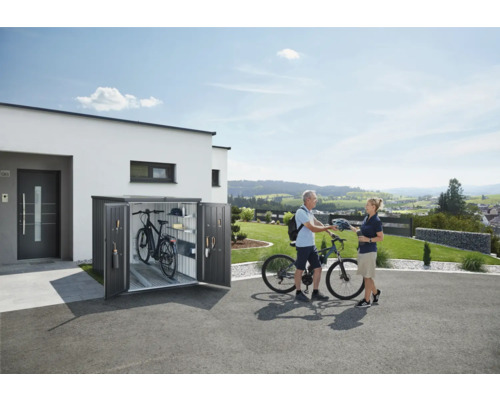 Box à vélos devant une maison avec deux vélos et deux personnes