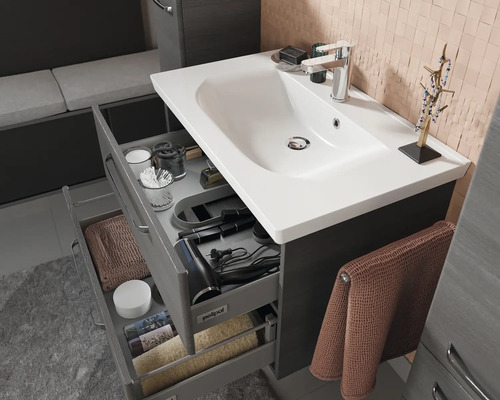 Meuble de lavabo de salle de bain avec tiroirs ouverts et divers articles de toilette