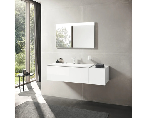 Salle de bains avec lavabo blanc, miroir et robinet devant une grande fenêtre.
