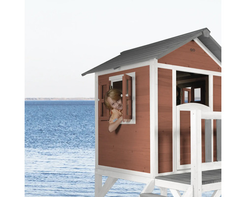 Cabane de jeu en bois avec enfant à la fenêtre sur la plage