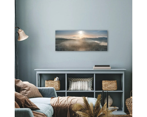 Salon avec une décoration murale représentant un paysage forestier enneigé dans le brouillard.