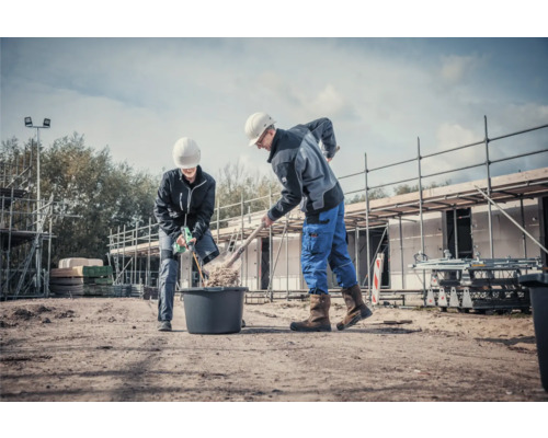 Zwei Bauarbeiter arbeiten mit Schaufel und Mörtelrührer auf einer Baustelle.
