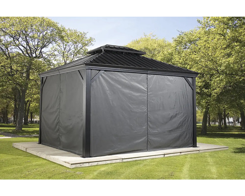 Pavillon avec rideaux sur une plateforme en bois dans un jardin