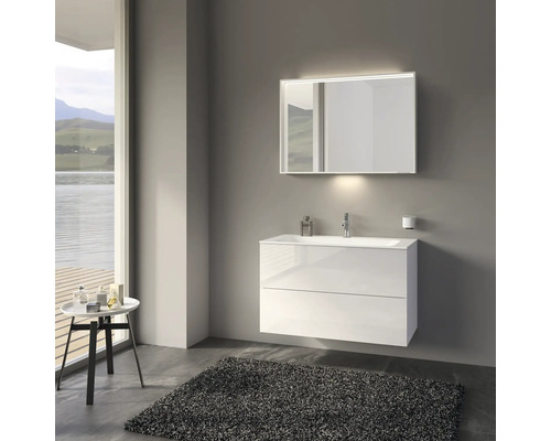 Salle de bains moderne avec meuble sous-lavabo blanc, miroir avec éclairage et tapis gris.