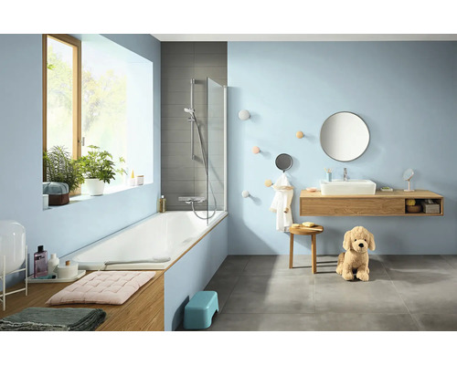 Salle de bain lumineuse avec baignoire, lavabo et décorations.