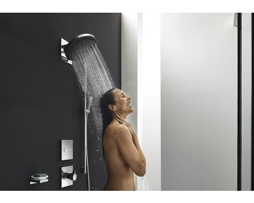 Frau unter einer Dusche mit Kopfbrause und Handbrause im Badezimmer