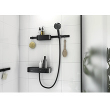 Badezimmer mit Duschstange, Brausekopf und Ablagen zur Aufbewahrung von Badartikeln an einer gefliesten Wand.