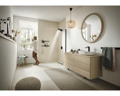 Salle de bains lumineuse avec douche, meuble-lavabo avec miroir, porte-serviettes et décoration