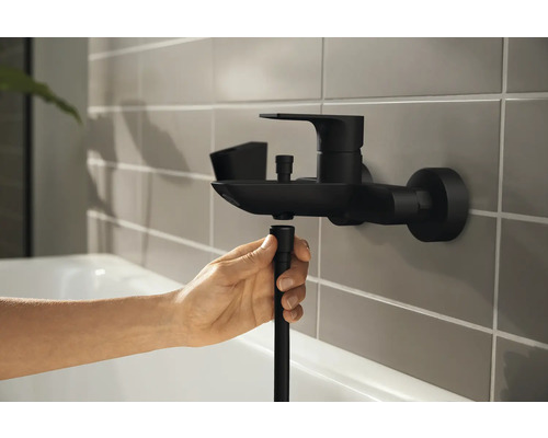 Robinet dans la salle de bain avec un tuyau de douche en cours de montage