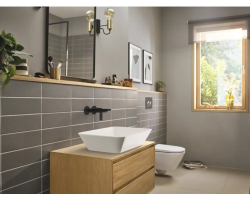 Modernes Badezimmer mit Waschtisch, Aufsatzwaschbecken, Spiegel und Toilette.