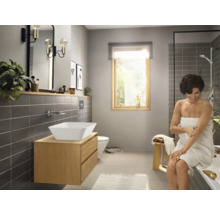 Salle de bain lumineuse avec lavabo sur meuble sous-lavabo, miroir et douche