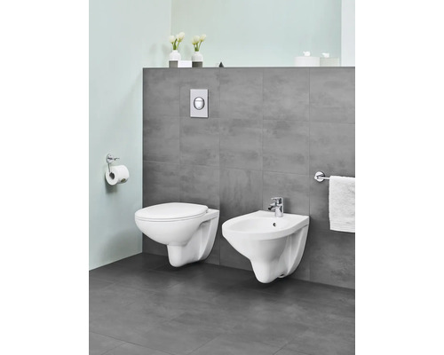 Modernes Badezimmer mit wandhängendem WC und Bidet in Weiss, ergänzt durch WC-Papierhalter und Handtuchhalter