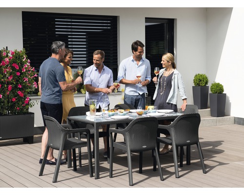 Gruppe von Personen, die an einem Gartentisch mit Glasplatte und Stühlen sitzen