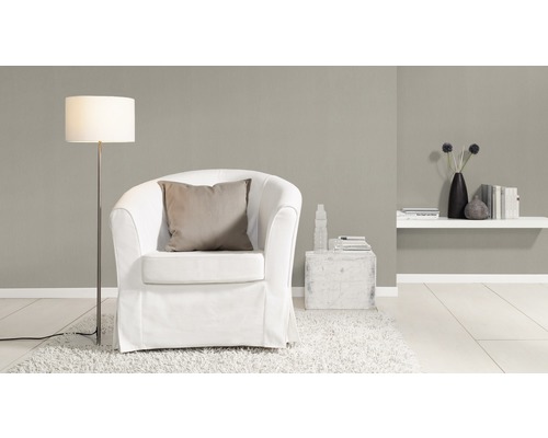 Wohnzimmer mit Sessel, Stehlampe und Wandregal