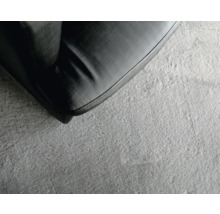 Gros plan d''un canapé noir sur un tapis gris.