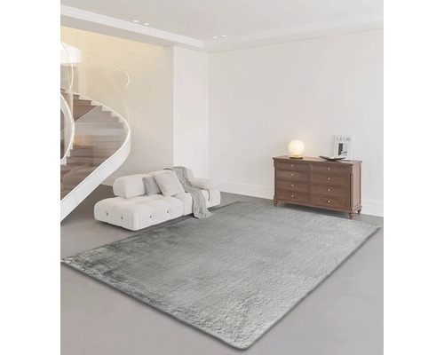 Séjour avec tapis gris clair, canapé, escalier et commode