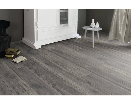 Intérieur avec sol stratifié imitation bois, commode, table et décoration