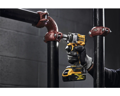 Logo DeWalt. Clé à chocs sans fil en utilisation sur une construction de tuyaux