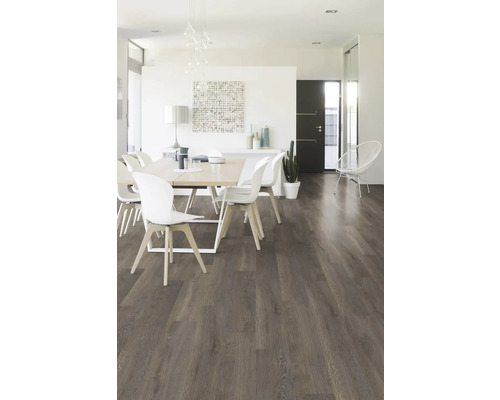 Salle à manger lumineuse avec table, chaises et sol stratifié imitation bois.