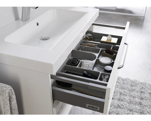 Meuble sous-lavabo avec tiroir ouvert et inserts de rangement pour accessoires de salle de bain