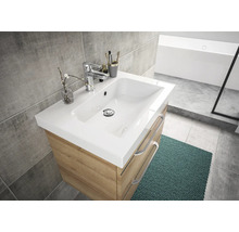 Meuble-lavabo avec meuble sous-vasque, robinet et décorations dans une salle de bain lumineuse