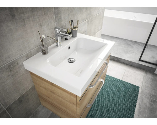 Meuble-lavabo avec meuble sous-vasque, robinet et décorations dans une salle de bain lumineuse