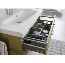 Badezimmerschrank mit Waschbecken und offenem Schubladenfach zur Aufbewahrung von Badutensilien.