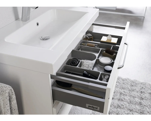 Meuble sous-lavabo avec tiroir ouvert et articles de toilette