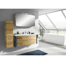 Salle de bains moderne avec meuble sous-lavabo, armoire de toilette et armoire haute aspect bois, baignoire sous une grande fenêtre.