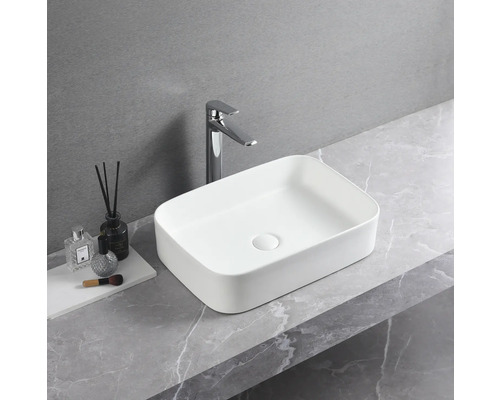 Vasque à poser rectangulaire en céramique avec robinet sur un plan de travail