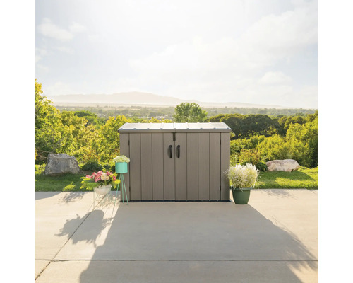 Gartenschrank aus Kunststoff mit Doppeltür und Griffen vor einer Landschaft.
