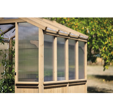Serre en bois avec parois transparentes dans le jardin