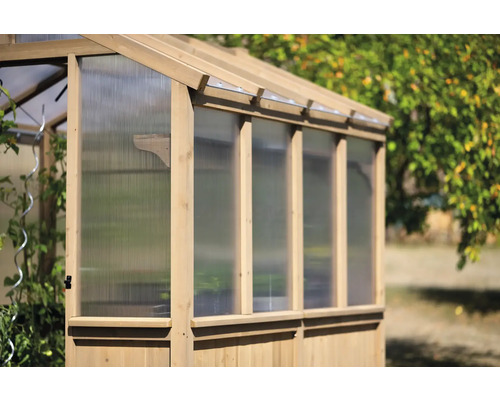 Serre en bois avec parois transparentes dans le jardin
