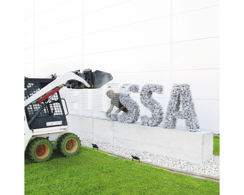 Construction d''un mur de gabions avec des pierres et une mini-chargeuse pour le support.
