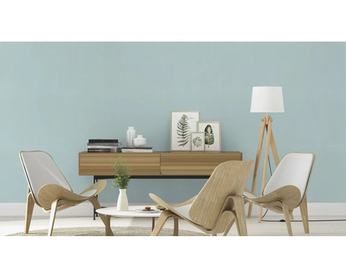 Salon moderne avec mur bleu clair, meubles en bois et lampe de lecture