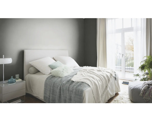 Schlafzimmer mit Bett, Nachttisch und Vorhängen für eine helle und freundliche Atmosphäre.