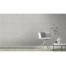 Mur clair avec papier peint à motifs, chaise et table d''appoint