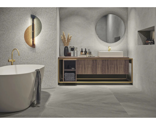Modernes Badezimmer mit Badewanne, Waschtisch und grauen Fliesen.