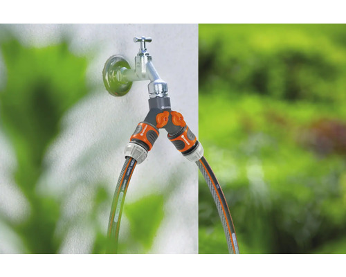 Distributeur d''eau Gardena sur un robinet avec deux tuyaux d''arrosage raccordés