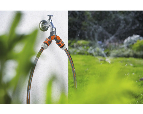 Robinet avec distributeur à deux voies et tuyaux d''arrosage raccordés pour l''irrigation du jardin