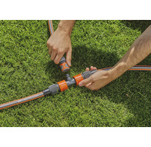 Scène d''arrosage de jardin avec raccord en T et raccords de tuyau sur gazon