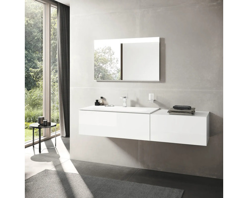 Salle de bains lumineuse avec lavabo, miroir et fenêtre.