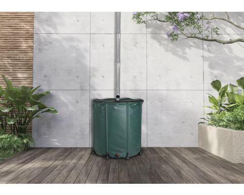 Regentonne aus Kunststoff mit Wasserablaufrohr im Garten