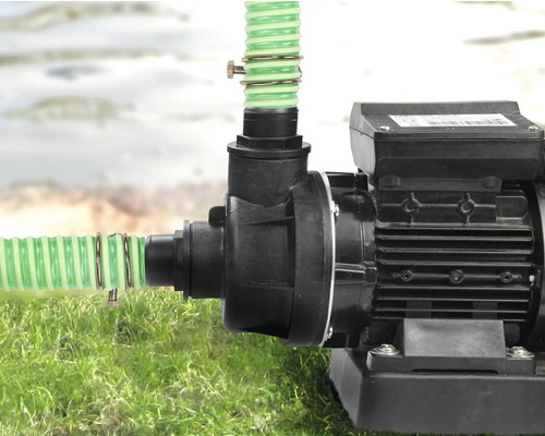 Pompe de jardin avec tuyaux raccordés sur une pelouse