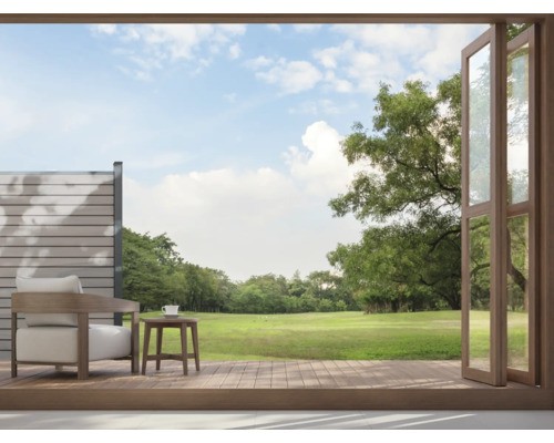 Balkonszene mit Sessel, Tisch und Blick auf einen grünen Garten